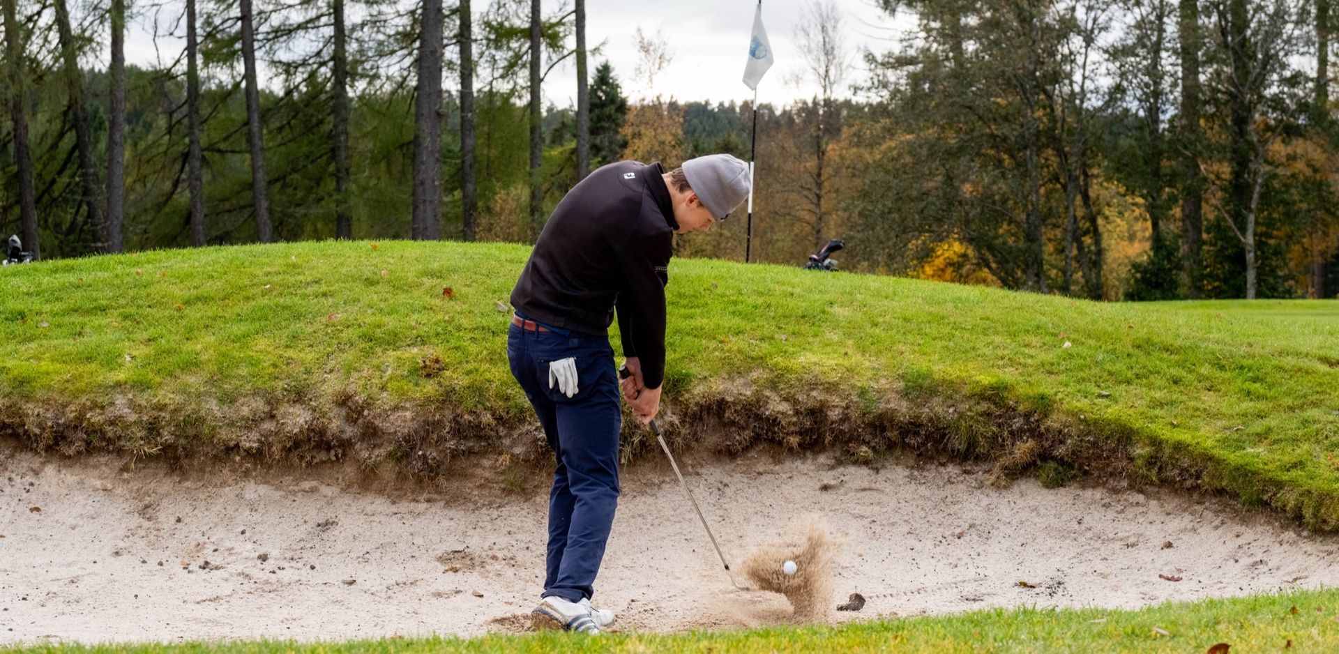 Golfspiller slår fra bunker på Sommersetra