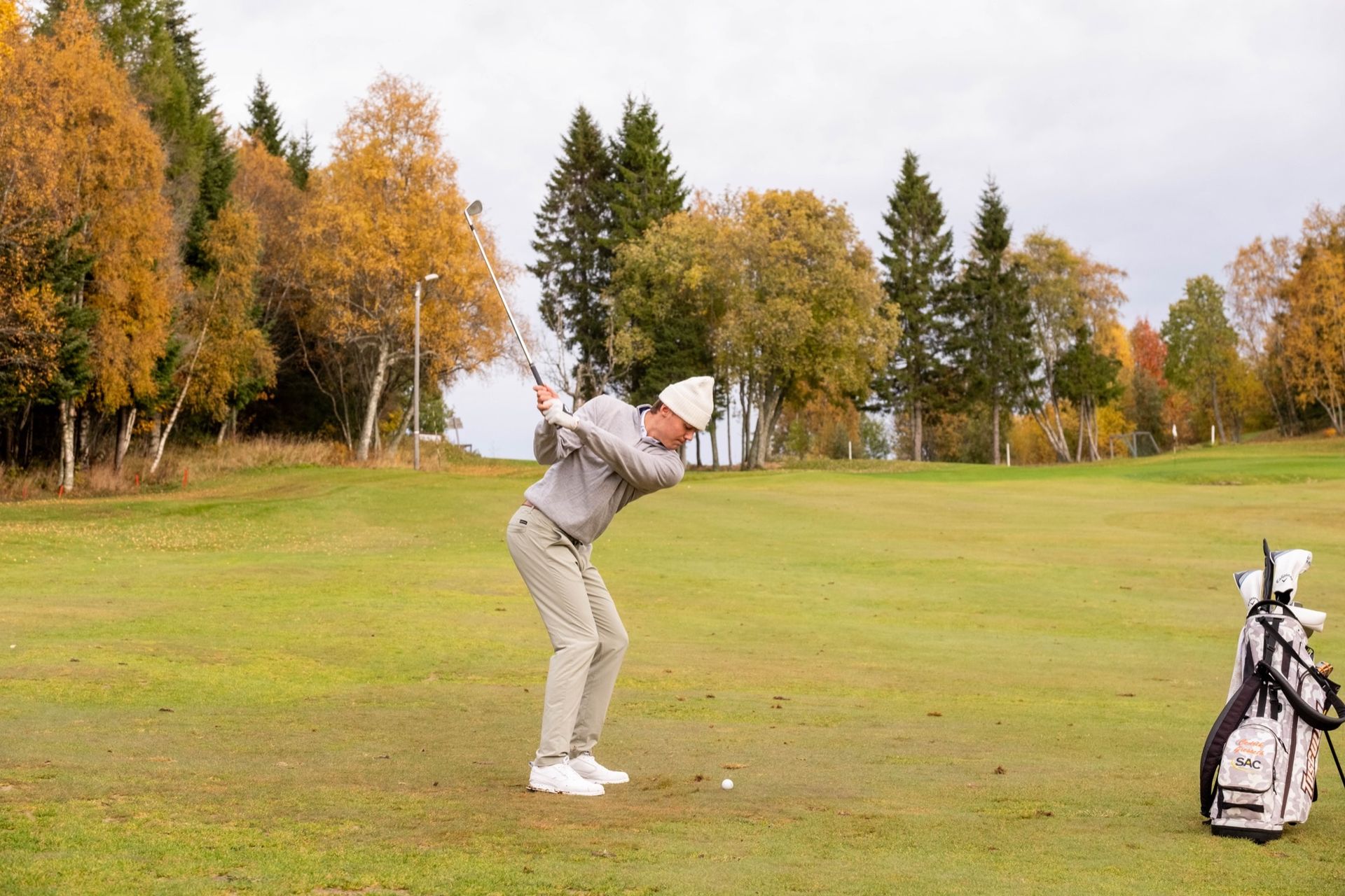 Golfspiller midt i svingen på fairway
